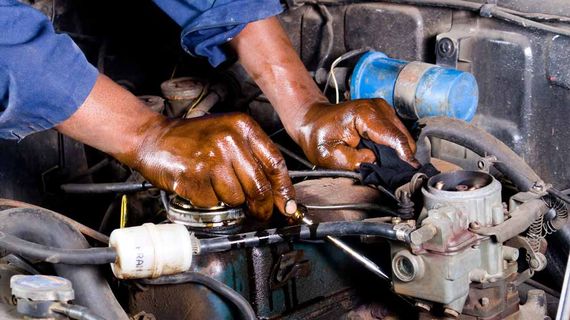 oily hands fixing engine